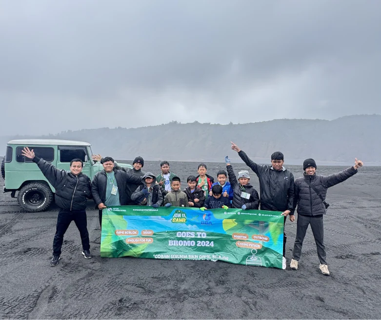 Kelompok peserta dan pendamping berfoto bersama dengan spanduk kegiatan di kawasan Bromo.