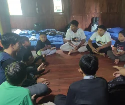 Peserta duduk melingkar dalam sesi diskusi di ruangan kayu.