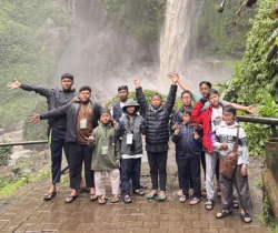 Peserta dan fasilitator berfoto bersama di dekat air terjun.