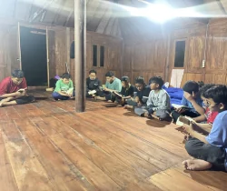 Peserta mengikuti diskusi dalam lingkaran besar di ruangan kayu.